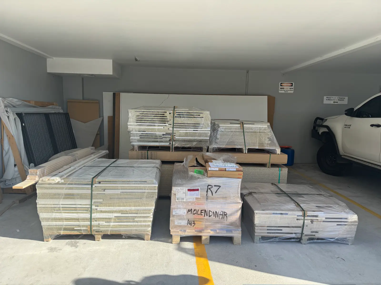 The R7 Molendinar flat-pack kitchen wrapped on pallets, delivered in full by Coastal Cut To Size